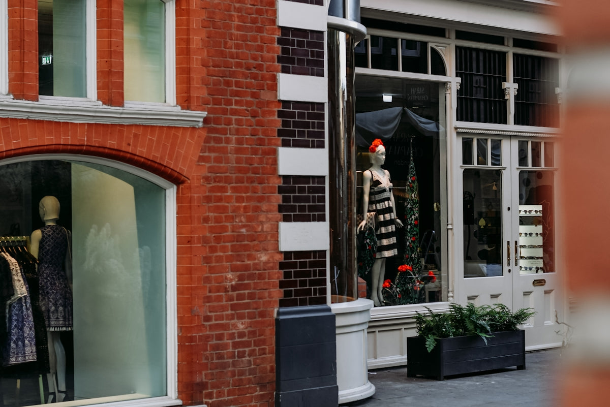a brick building with a display of mannequins in the window