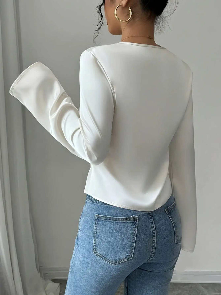 Eine weiße Langarmbluse mit ausgestellten Ärmeln kombiniert mit blauen Jeans. IsabellBoutique030