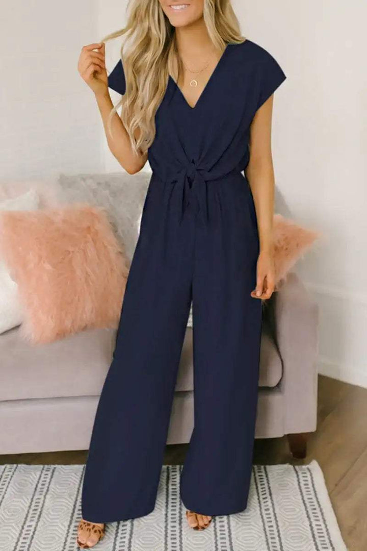 Marineblauer Jumpsuit mit V-Ausschnitt und Schleife vorne. Elegante Damenmode. IsabellBoutique030