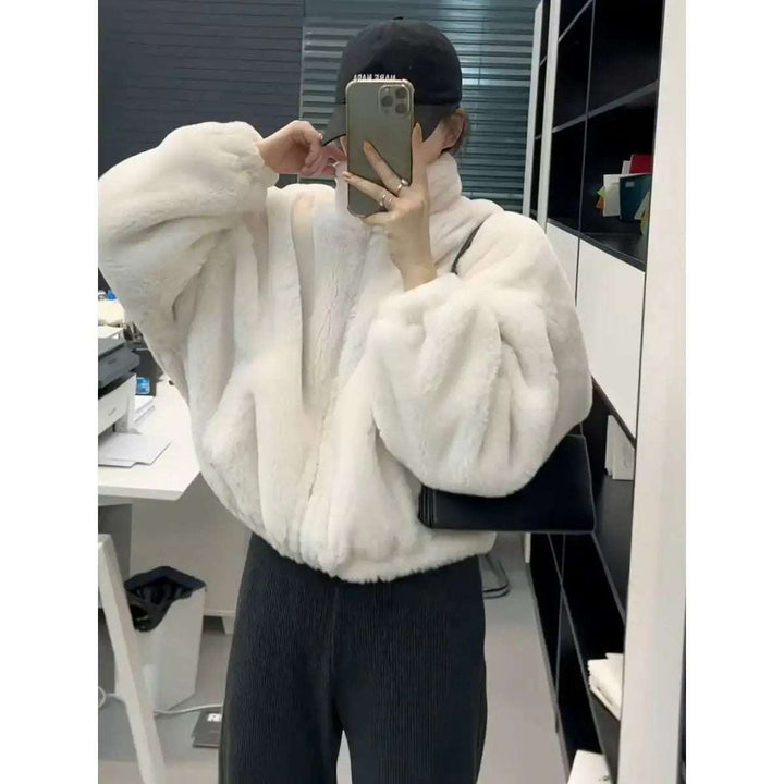 Weiße Kunstfelljacke mit Stehkragen und Puffärmeln, dazu schwarze Strickhose. IsabellBoutique030