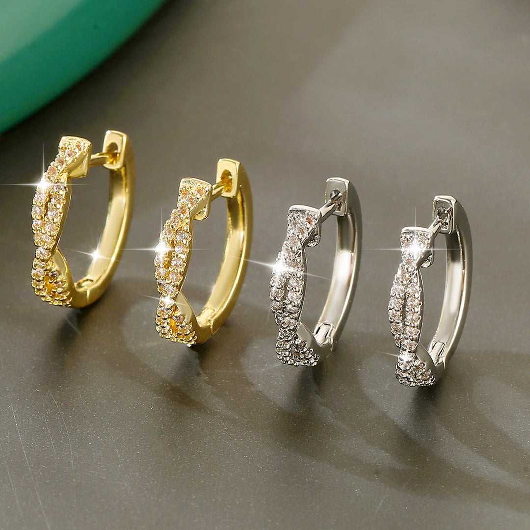 Zwei Paar elegante Creolen-Ohrringe, eines in Gold mit Zirkonia besetzt, das andere in Silber mit Zirkonia. IsabellBoutique030.