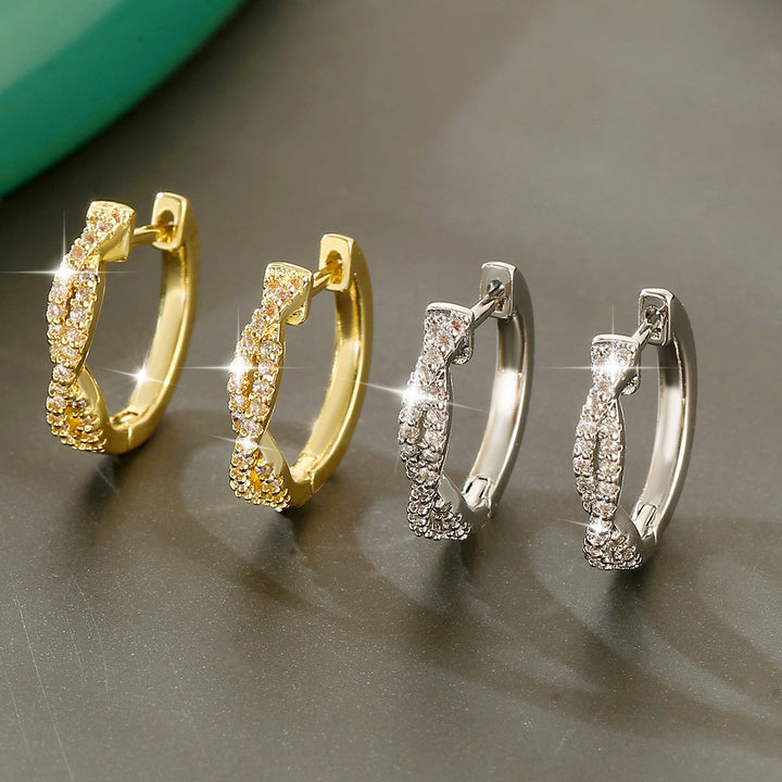 Zwei Paar elegante Creolen-Ohrringe, eines in Gold mit Zirkonia besetzt, das andere in Silber mit Zirkonia. IsabellBoutique030.