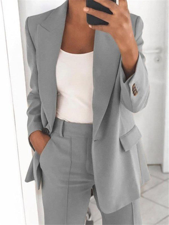 Grauer Damen-Zweiteiler-Anzug: Blazer mit Reverskragen, weißes Top, Anzughose mit Taschen. IsabellBoutique030