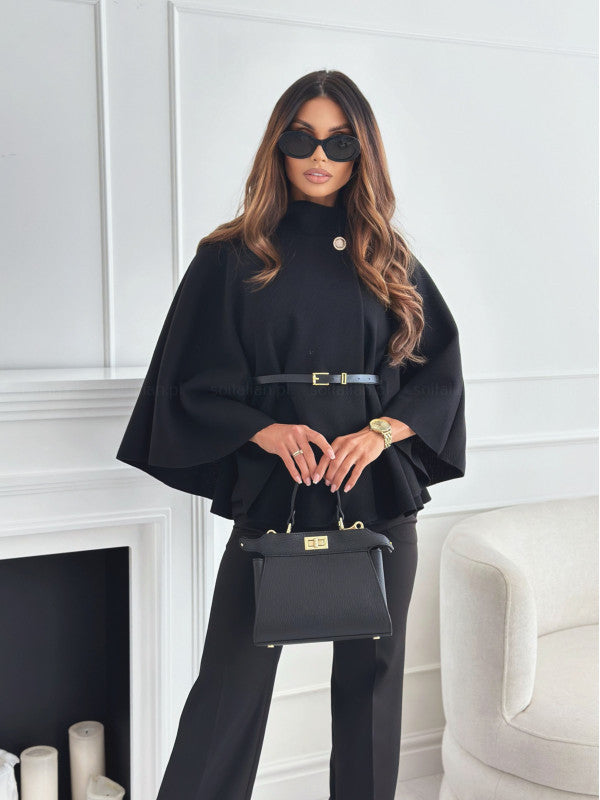 Schwarzes Poncho-Cape mit goldenem Knopfdetail, Gürtel und schwarzer Handtasche. IsabellBoutique030