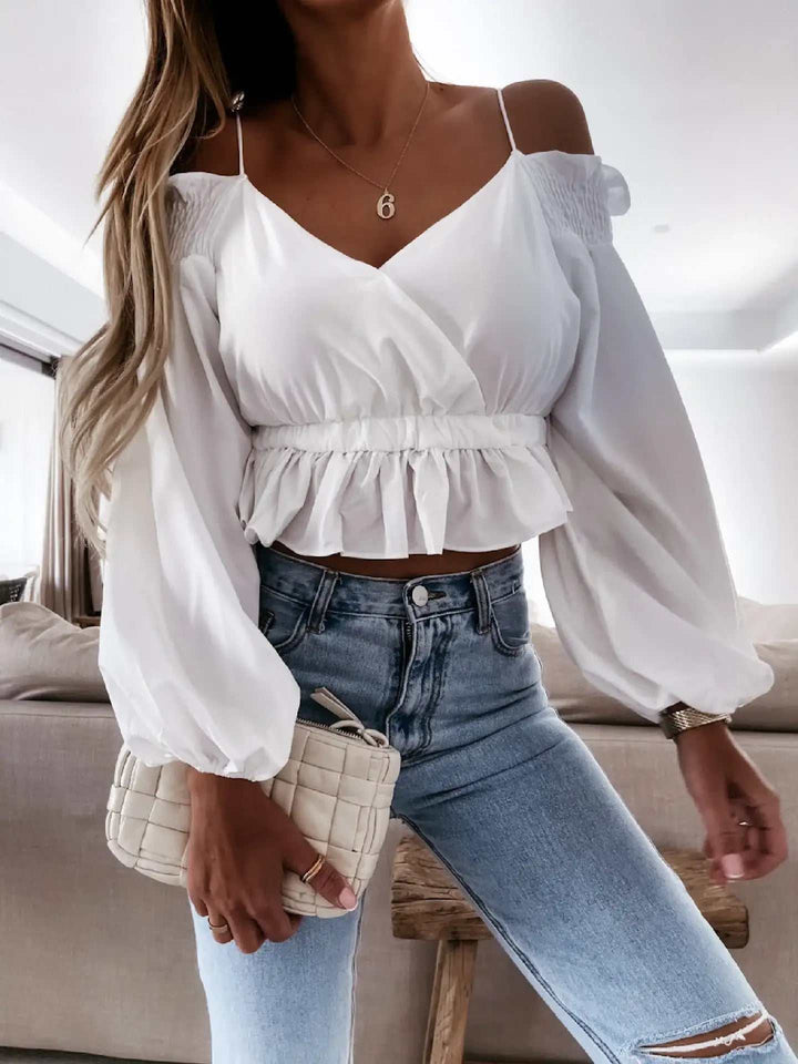 Weiße schulterfreie Wickelbluse mit Puffärmeln und Rüschenbund, kombiniert mit blauen Röhrenjeans. IsabellBoutique030