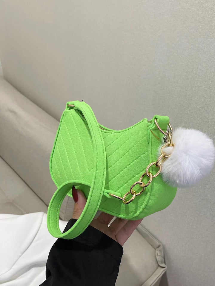 Leuchtend grüne Filz-Umhängetasche mit gestepptem Muster und goldener Kette, verziert mit einem flauschigen weißen Bommel. IsabellBoutique030