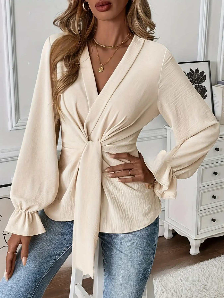 Cremefarbene Wickelbluse mit tiefem V-Ausschnitt und Ballonärmeln, Knoten vorne. IsabellBoutique030