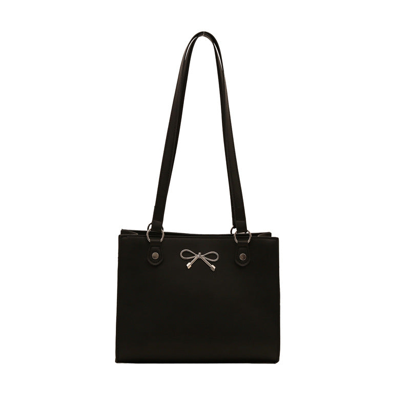 Schwarze Henkeltasche mit Schleifen-Applikation vorne und schmalen Trägern. IsabellBoutique030.
