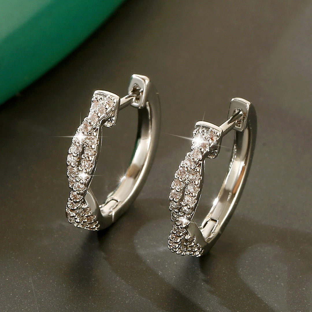 Glänzende Silber-Creolen mit Zirkonia-Besatz, elegant verdrehtes Design. IsabellBoutique030