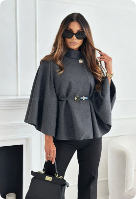 Dunkelgrauer Poncho-Mantel mit Stehkragen, Taillengürtel und goldenem Knopf, kombiniert mit schwarzen Hosen. IsabellBoutique030