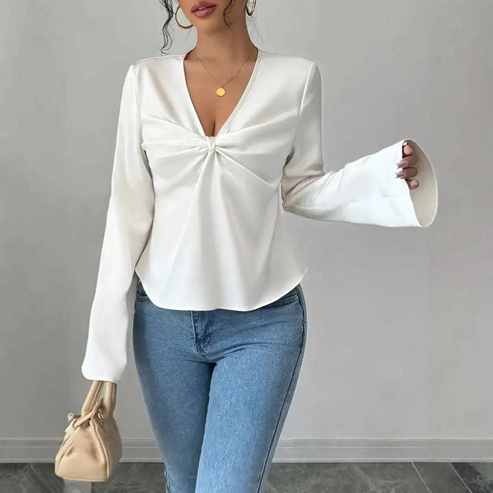 Weiße Wickelbluse mit V-Ausschnitt und Trompetenärmeln, kombiniert mit blauer Jeans. IsabellBoutique030