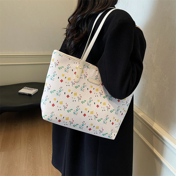 Weiße Shopper-Tasche mit buntem Blumenmuster und weißen Henkeln. IsabellBoutique030