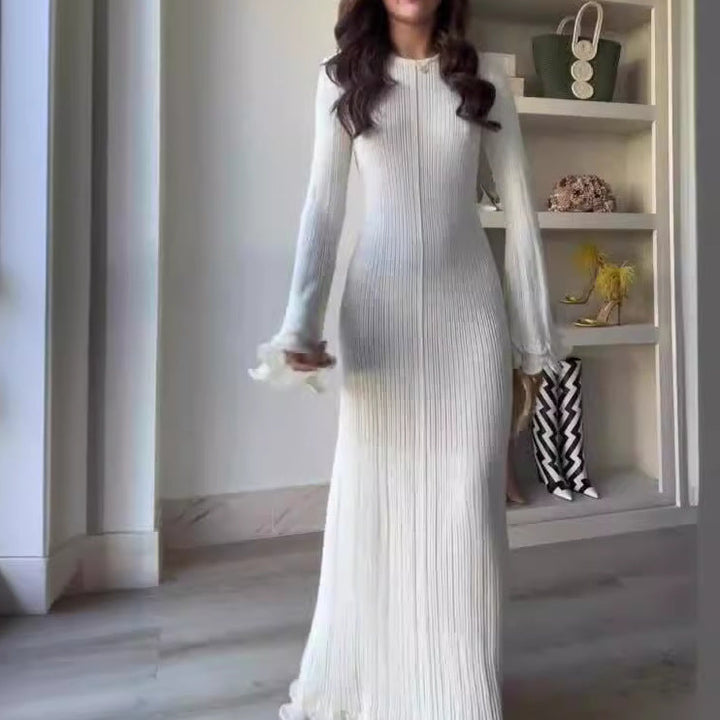 Eine Frau trägt ein weißes Strickkleid mit langen Ärmeln und gerüschten Manschetten. IsabellBoutique030