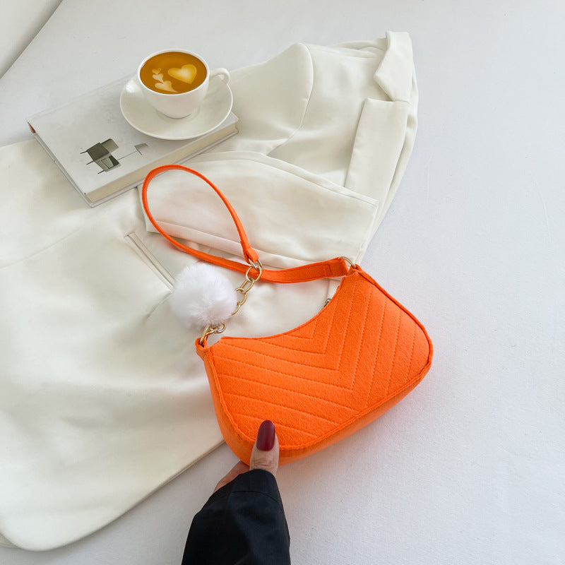 Kleine orange Handtasche mit Chevron-Steppung und weißem Bommel-Anhänger, schick für Damen. IsabellBoutique030