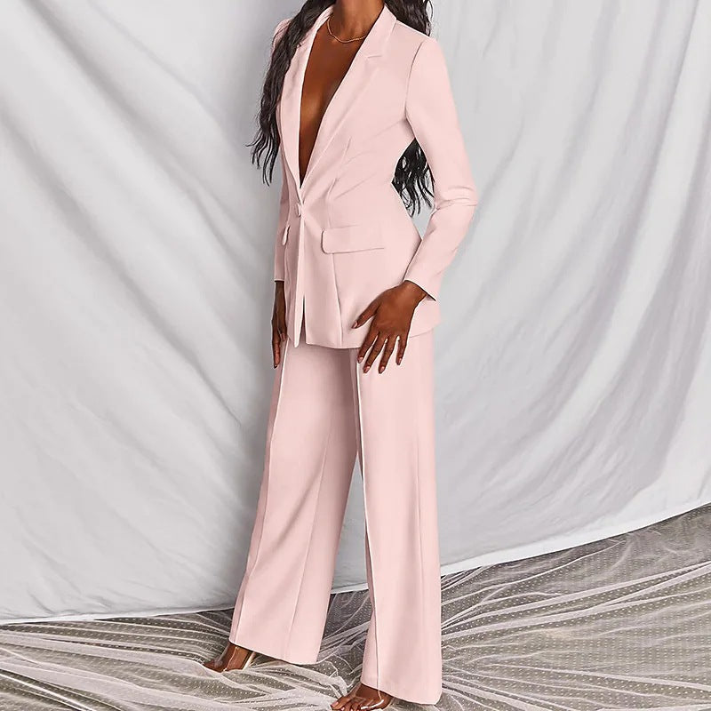 Frau in einem zartrosa Anzug mit weitem Bein und tiefem Ausschnitt. Eleganter Hosenanzug für Damen. IsabellBoutique030