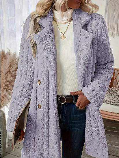 Lila Strickmantel mit Zopfmuster und Knöpfen, getragen von einer Frau mit weißem Rollkragenpullover und Jeans. IsabellBoutique030