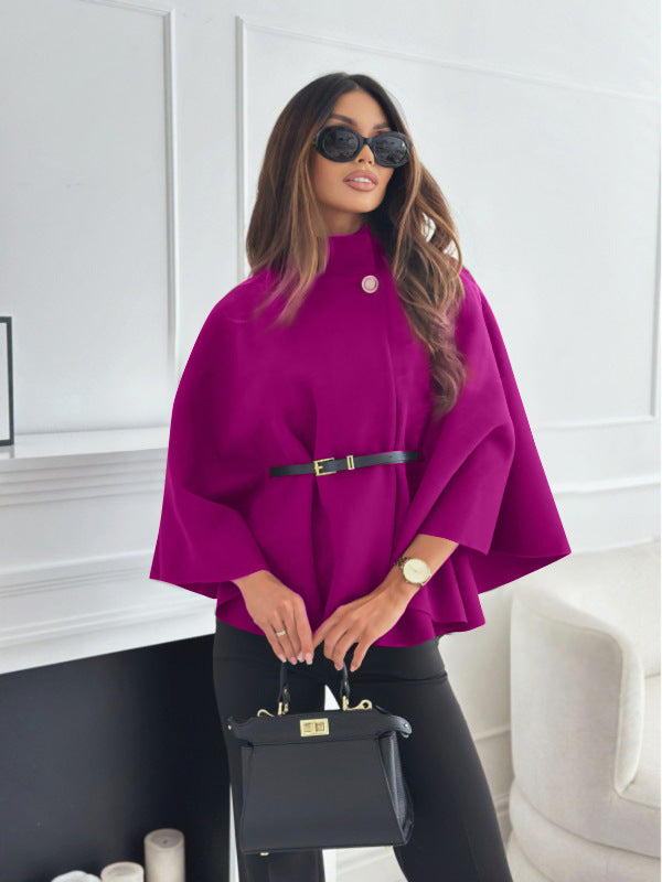 Modische pinke Cape-Jacke mit Schößchen, Gürtel und Knopfdetail, getragen von Frau mit Sonnenbrille und schwarzer Tasche. IsabellBoutique030.