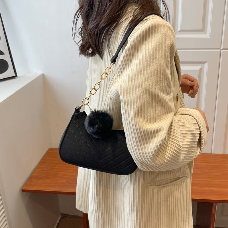 Schwarze Stepptasche mit Zickzack-Muster, Goldkette und schwarzem Bommel. IsabellBoutique030