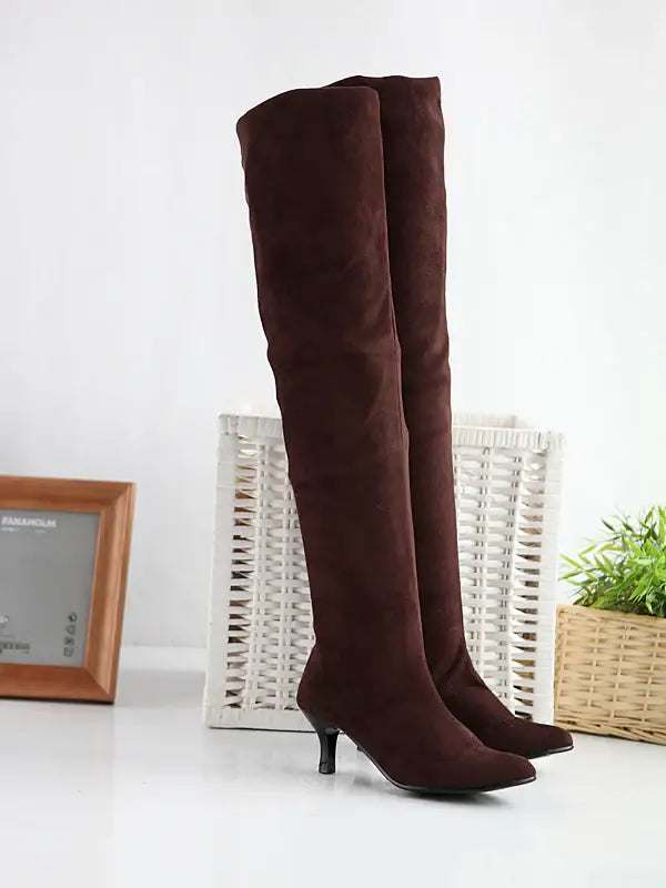 Elegante Dame trägt schwarze Wildlederstiefel mit hohem Schaft und Stiletto-Absatz